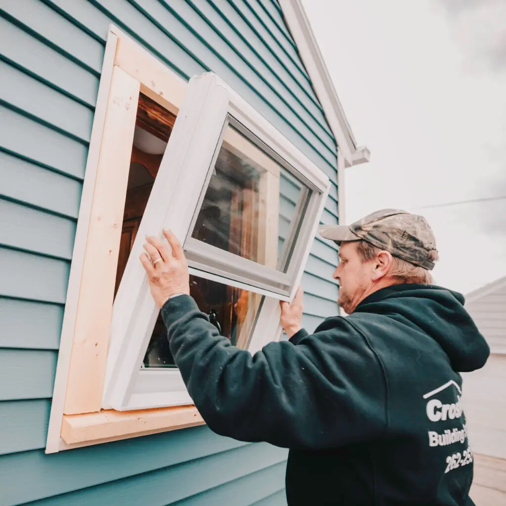 Mammoth Home Renovations worker installing a brand new window in the newly installed wood framing.