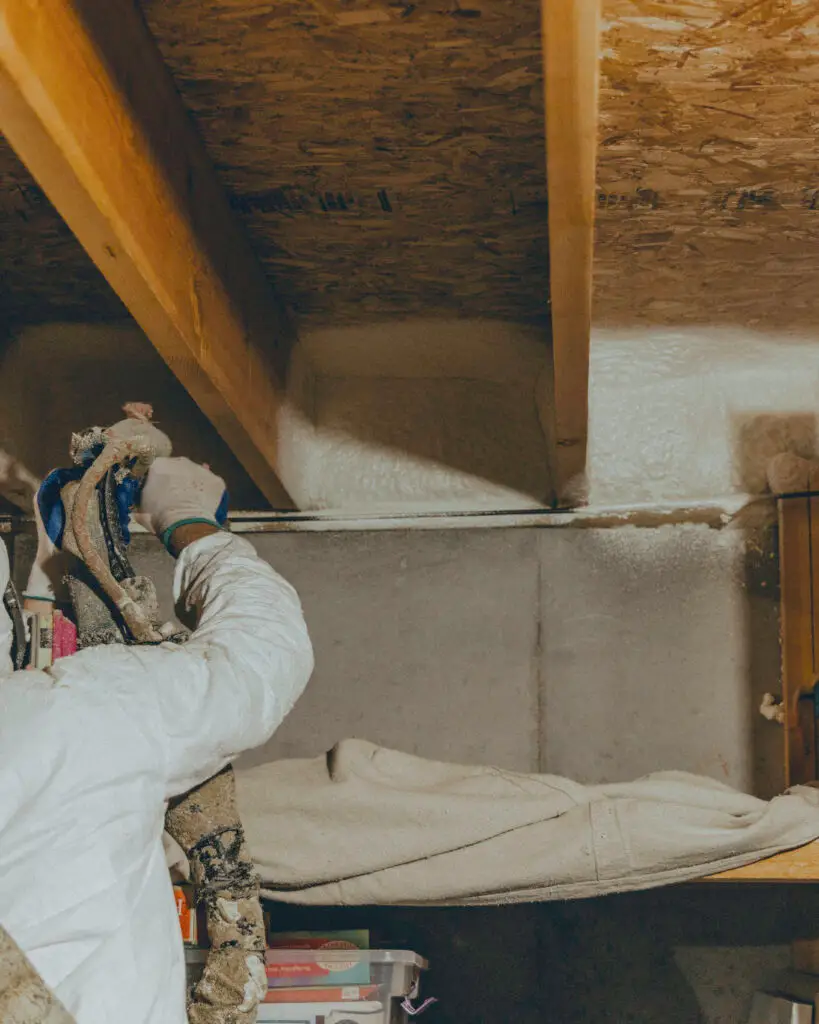 Mammoth Renovations Installer applying Spray Foam Insulation to the ceiling of a basement