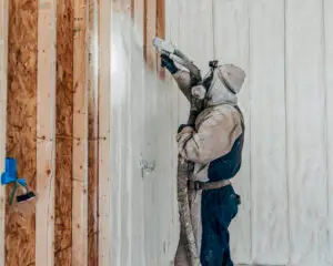 Mammoth Renovations Installer applying Spray Foam Insulation to the wall of a garage.